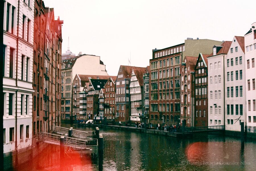 Historic canal view of Nikolaifleet in Hamburg with brick buildings, waterway, and pedestrian edge
